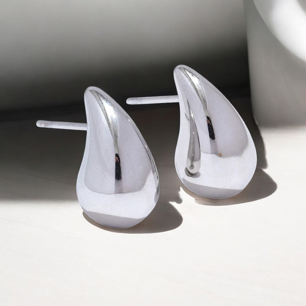 Silver teardrop earrings on a light gray background