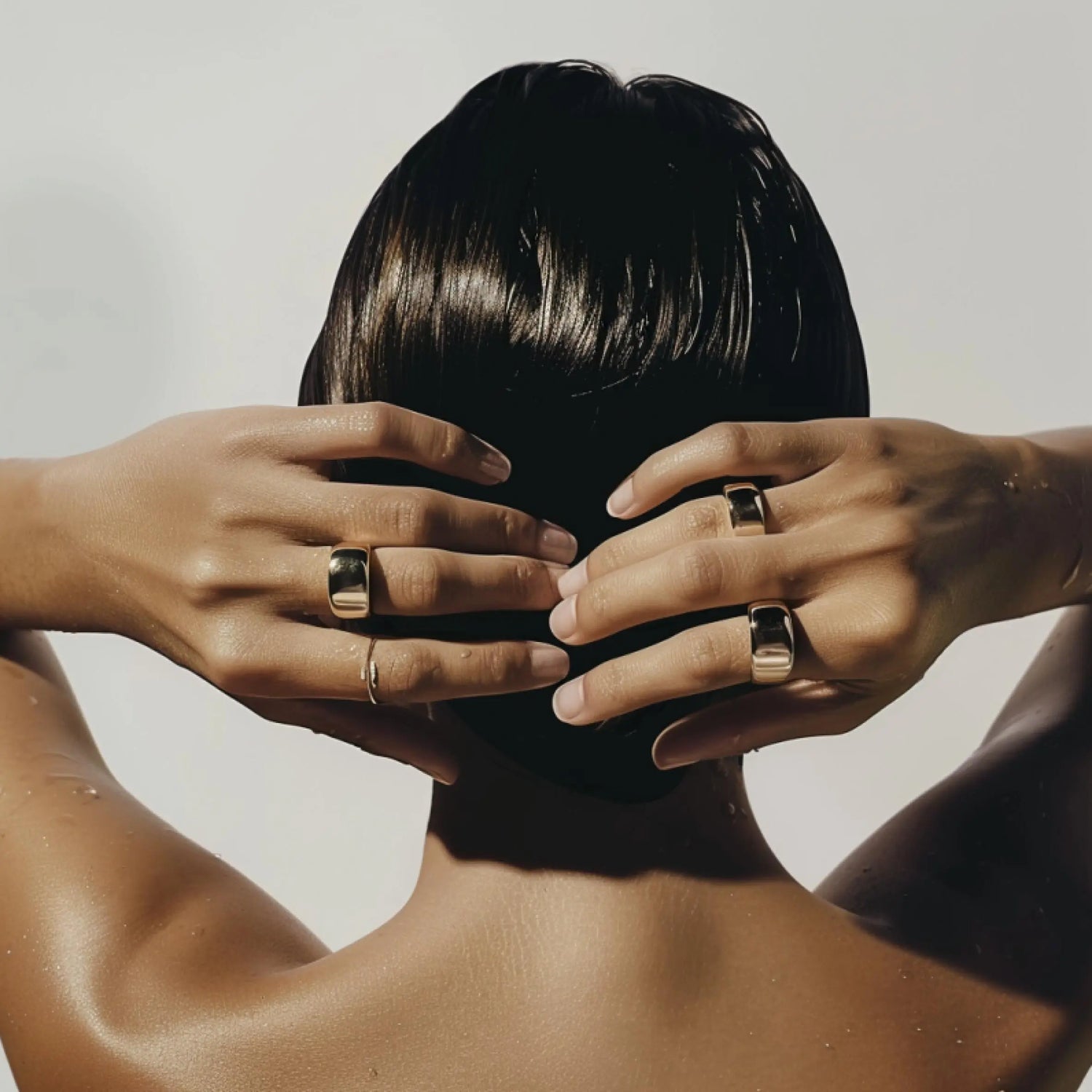 women wearing gold rings and giving us her back