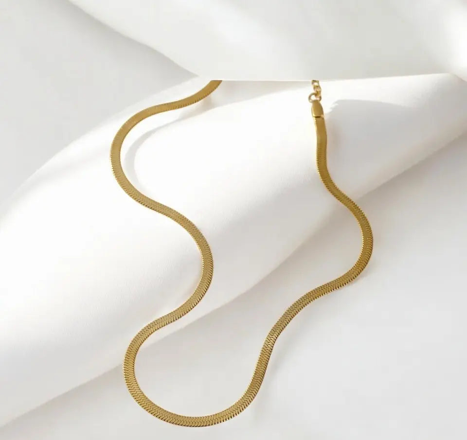 Gold necklace on a white fabric background