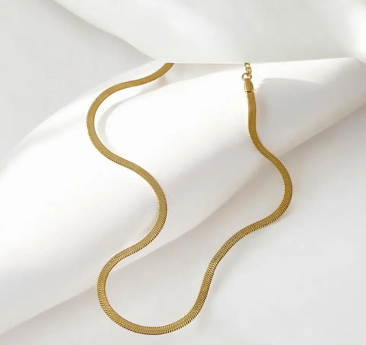 Gold necklace on a white fabric background