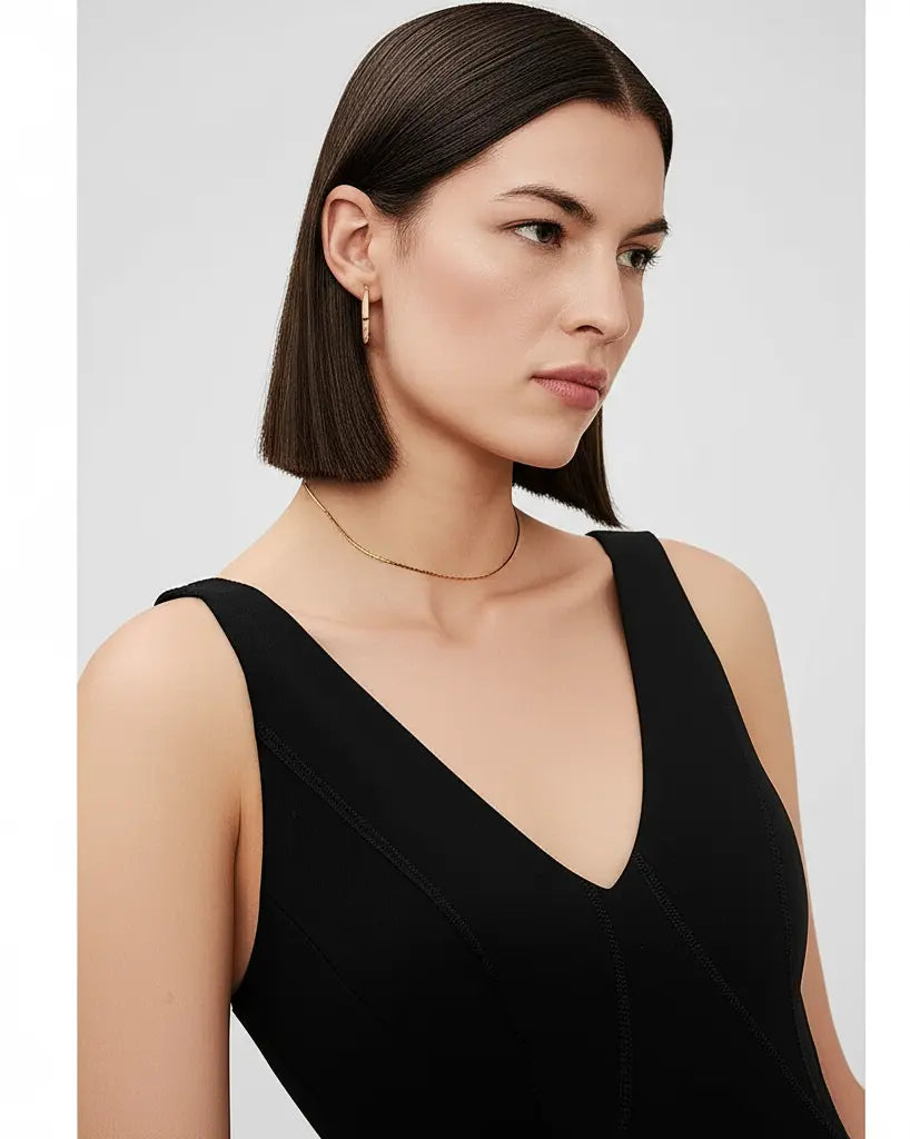 Woman wearing a black sleeveless top against a plain background