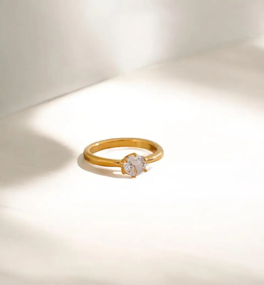 Gold ring with a diamond on a light background