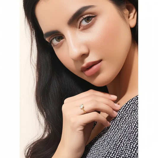Close-up of a woman wearing a gold ring on a beige background