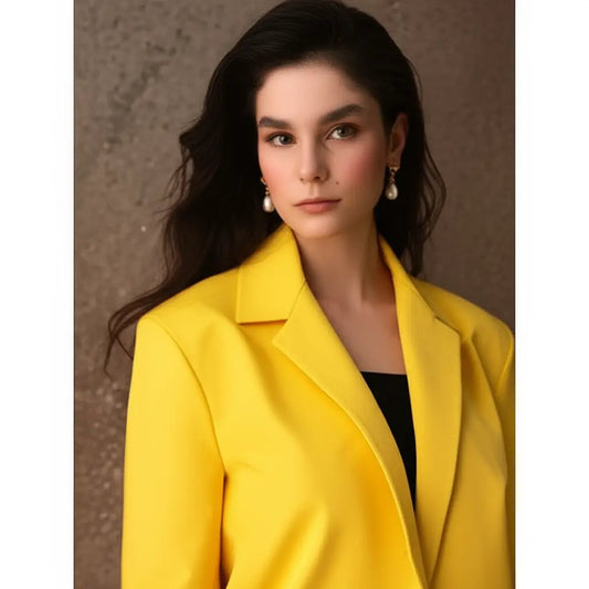 Woman wearing a bright yellow coat against a neutral background