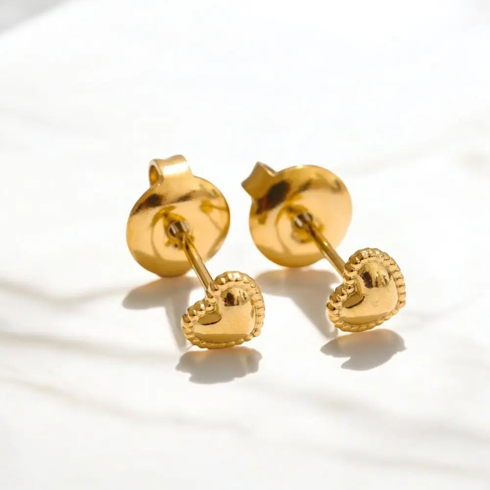 Pair of gold heart-shaped earrings on a light background