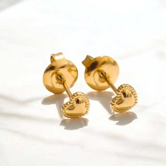 Pair of gold heart-shaped earrings on a light background