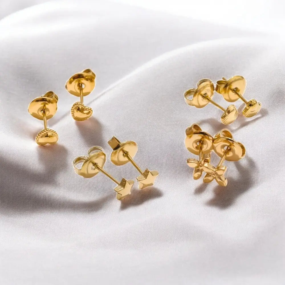 Pair of gold earrings on a white fabric background
