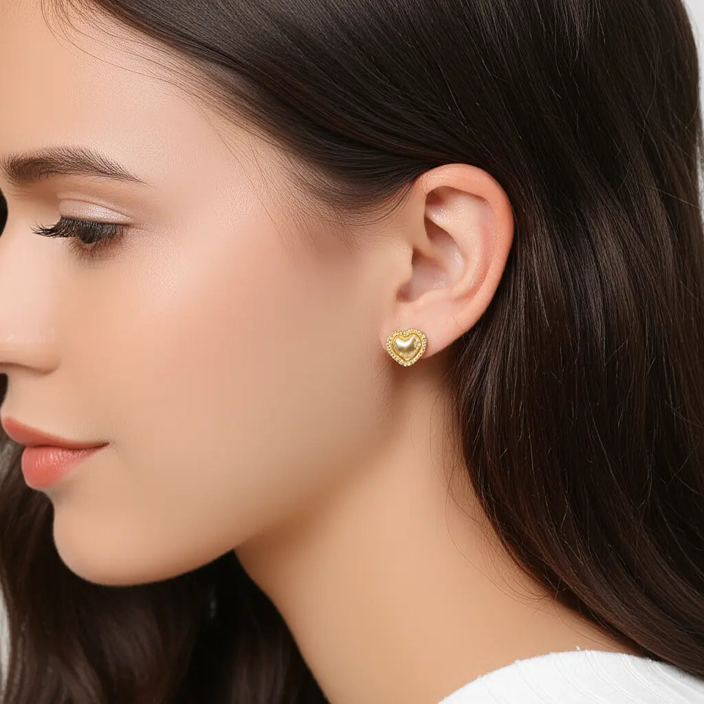 Close-up of a woman wearing gold heart-shaped earrings.