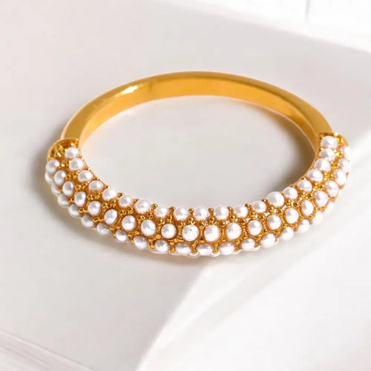 Gold and pearl necklace on a white background
