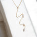 Gold necklace with small pendants on a white background