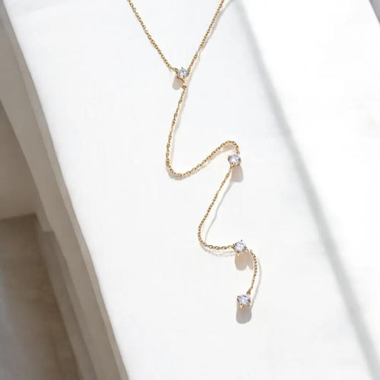 Gold necklace with small pendants on a white background