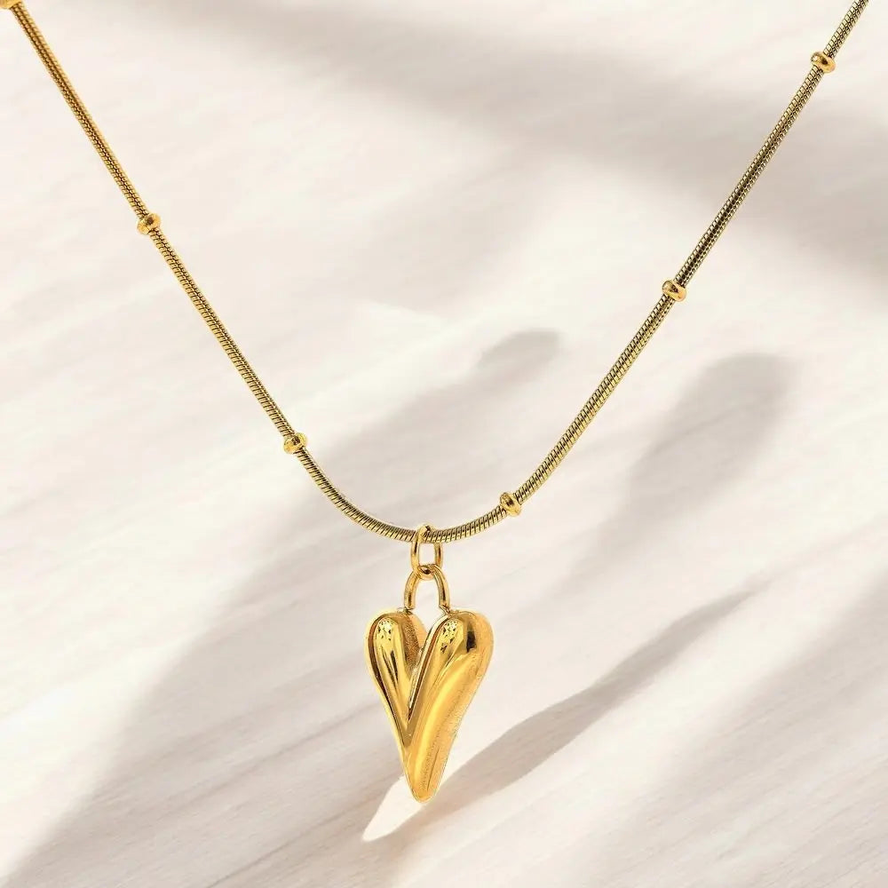 Gold heart-shaped pendant necklace on a light background