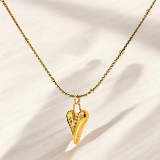 Gold heart-shaped pendant necklace on a light background