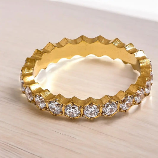 Gold ring with diamond stones on a light wooden background