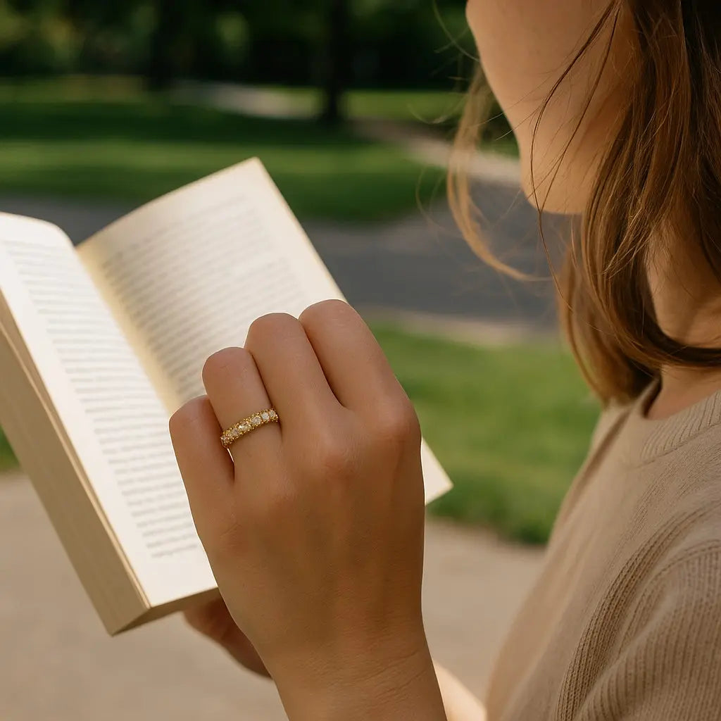 Person reading a book outdoors with a blurred natural background