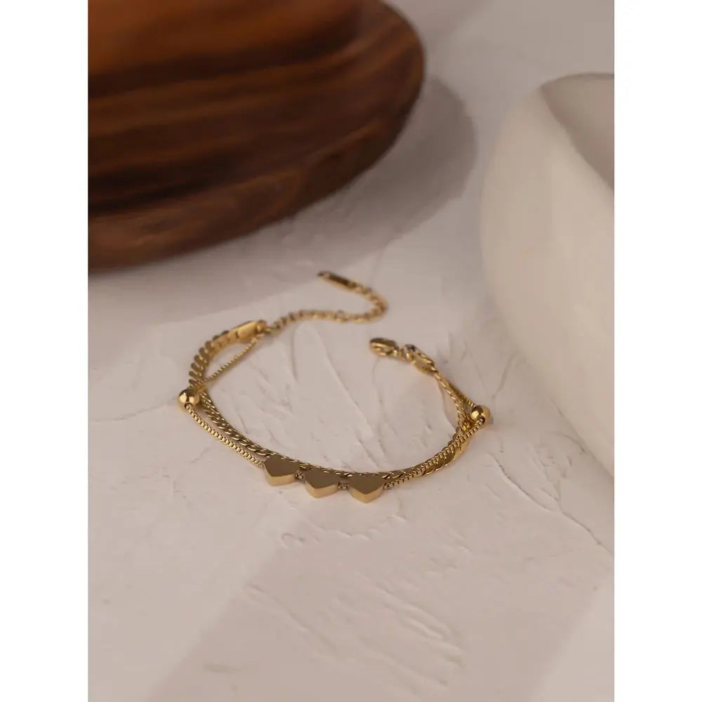 Gold bracelet on a textured beige surface