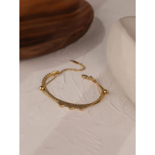 Gold bracelet on a textured beige surface