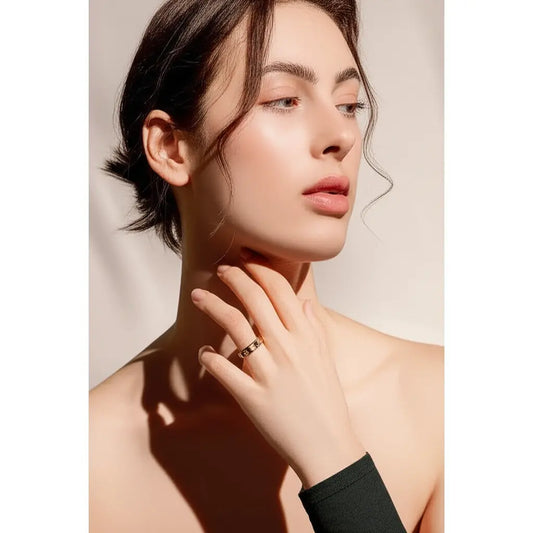 Woman wearing a ring on her finger with a neutral background