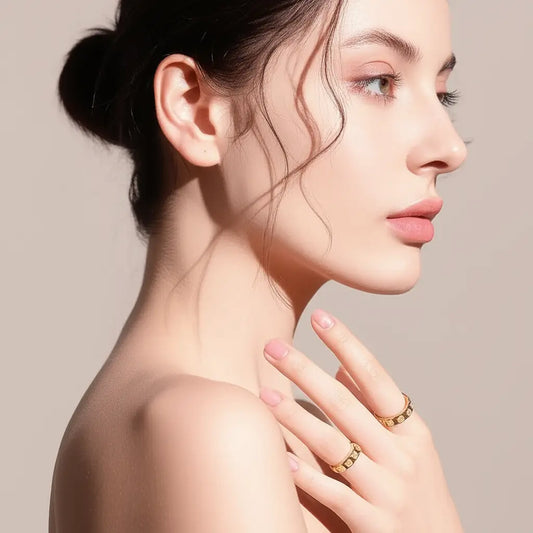 Woman wearing gold rings on a beige background