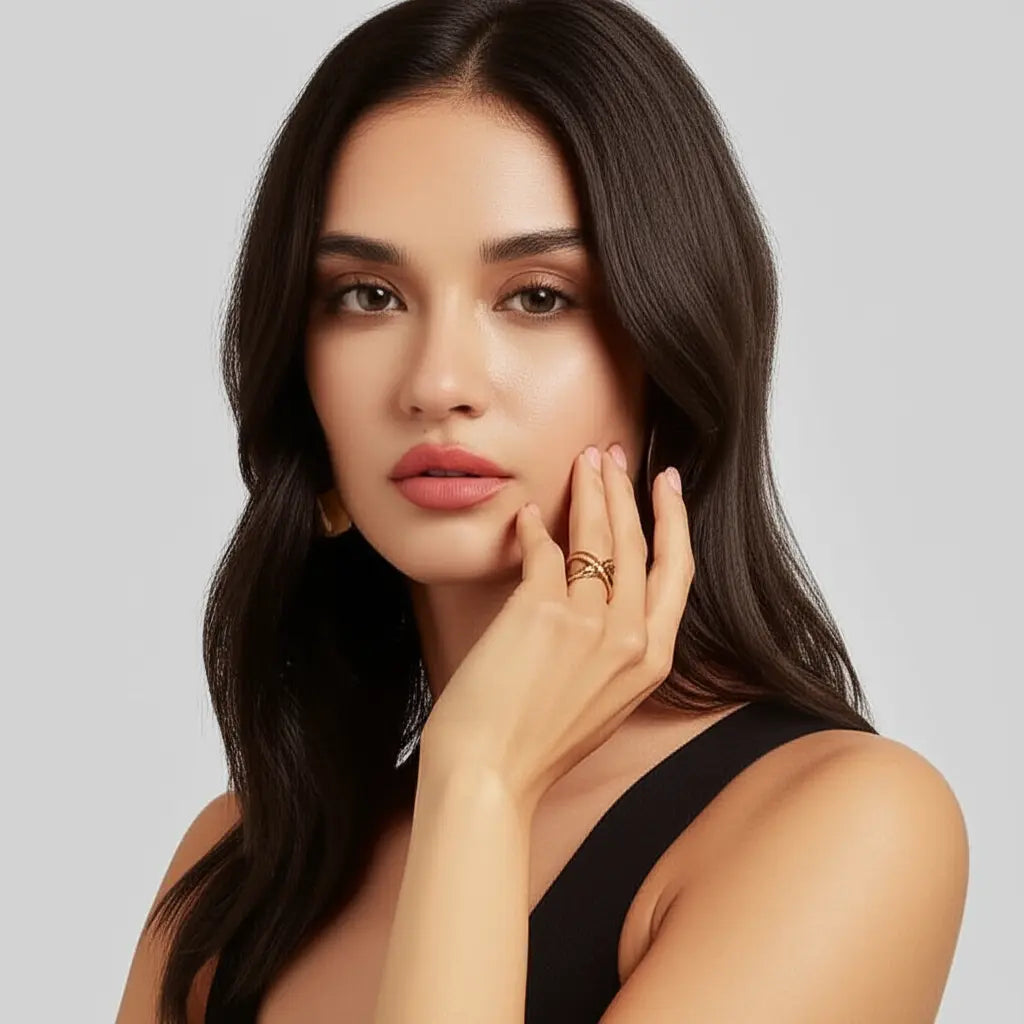 Woman with long dark hair and a black top against a light gray background