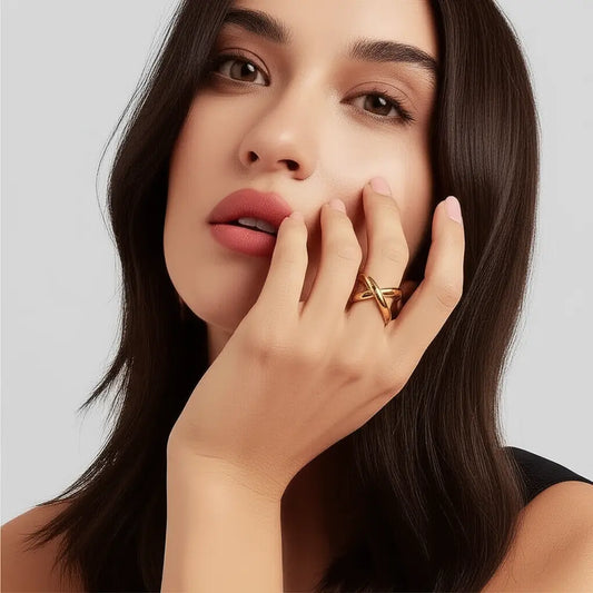 Woman with a gold ring on her finger against a neutral background