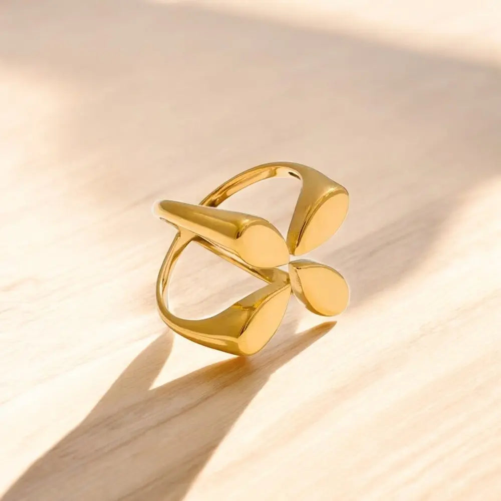 Gold ring with a unique design on a beige background