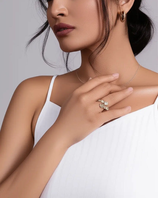 Woman wearing a necklace, ring, and earrings on a plain background