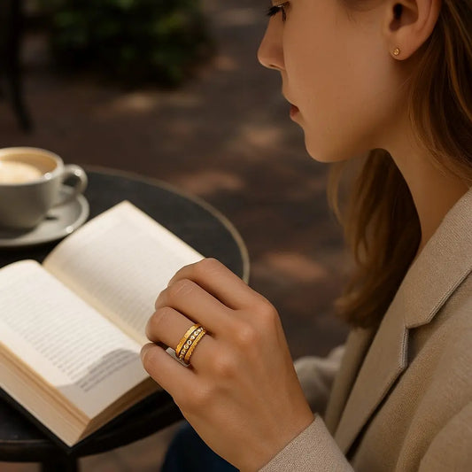 Woman reading a book with a cup of coffee on a blurred outdoor background