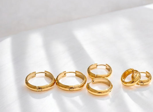 Set of gold hoop earrings on a white background