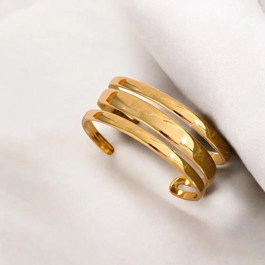 Gold bracelet on a light beige background