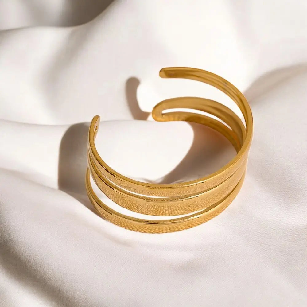 Gold bracelet on a white fabric background