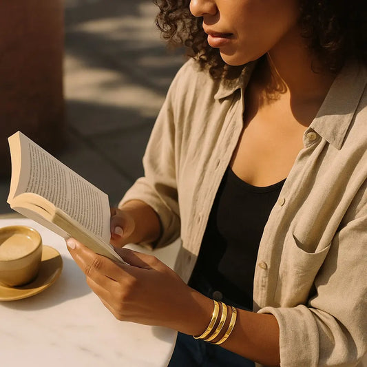 Person reading a book with a cup of coffee on a table