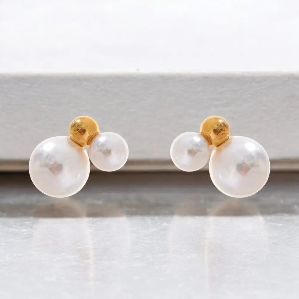 Pair of pearl earrings with gold tops on a white background