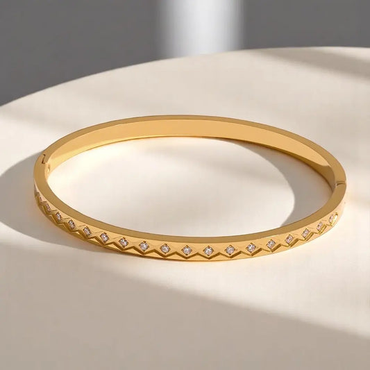Gold bracelet with diamond accents on a light surface