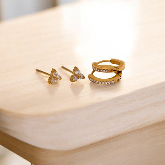 Gold jewelry set with earrings and a ring on a wooden surface