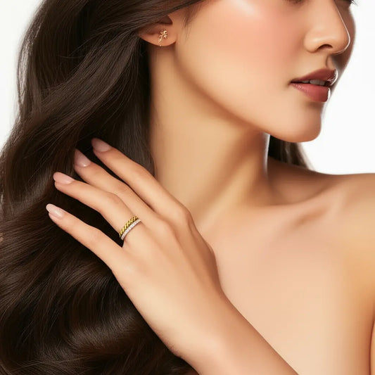 Close-up of a woman wearing a gold ring and earring on a white background