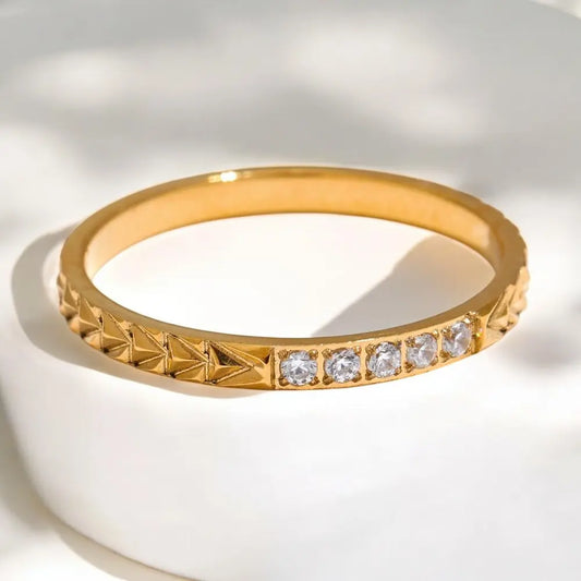 Gold ring with diamond accents on a white background