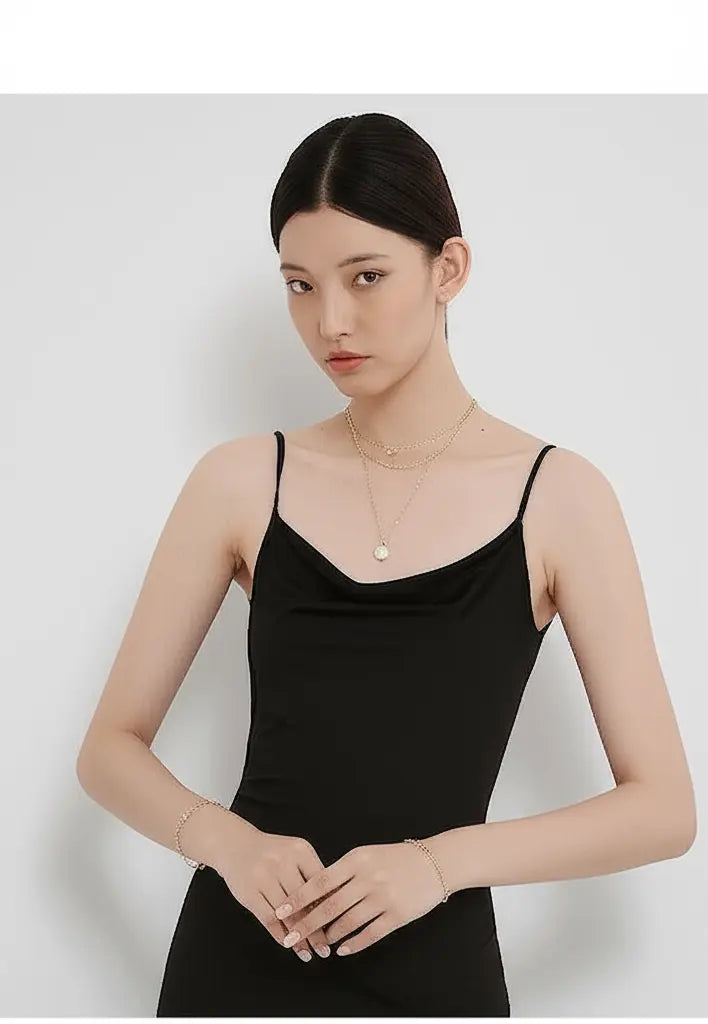 Woman wearing a black sleeveless top against a white background