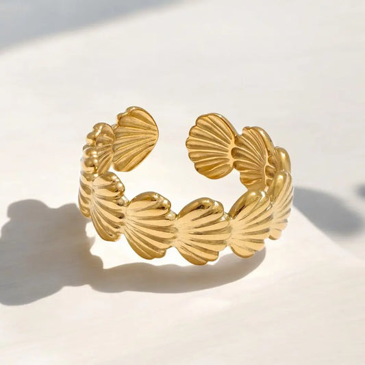 Gold bracelet with shell-like designs on a light background