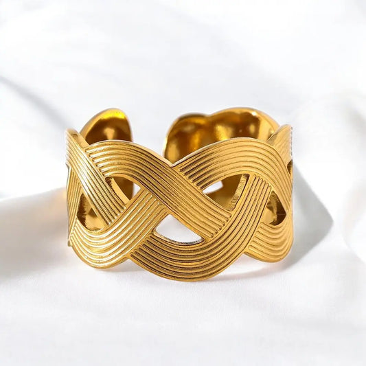 Gold bracelet with a braided design on a white background
