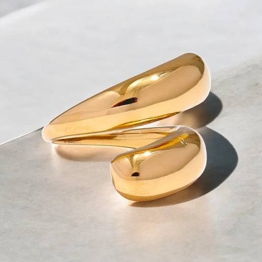 Two gold rings on a light gray surface