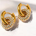 Gold hoop earrings with clear gemstones on a light background