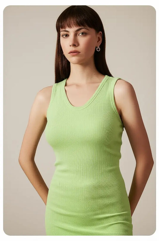 Woman wearing a light green sleeveless dress against a neutral background