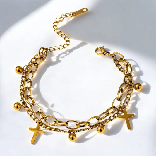 Gold chain bracelet with various charms on a white background