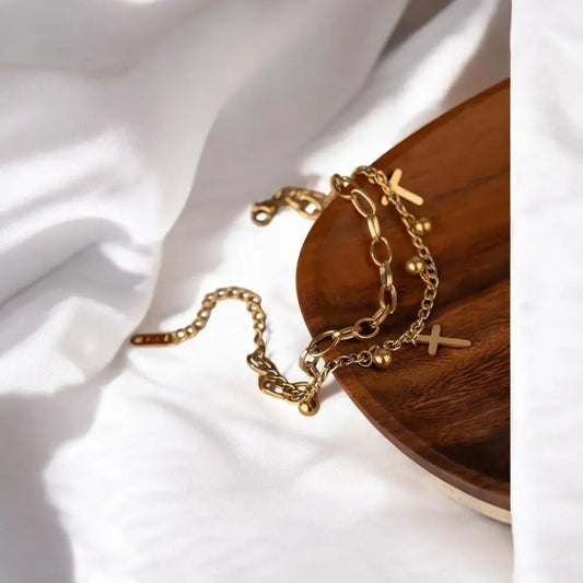 Gold chain necklaces with cross pendants on a wooden surface