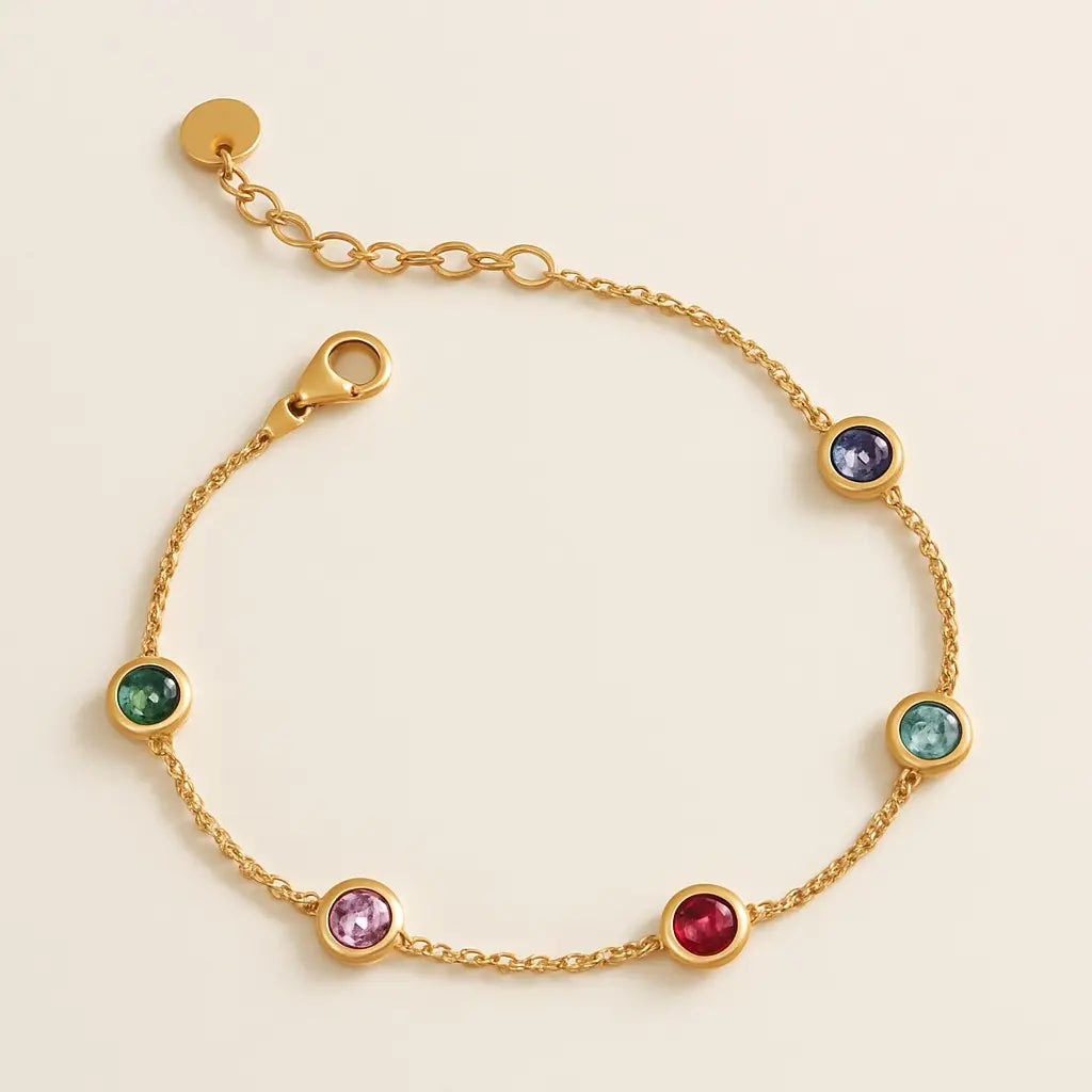 Gold bracelet with colorful gemstones on a beige background