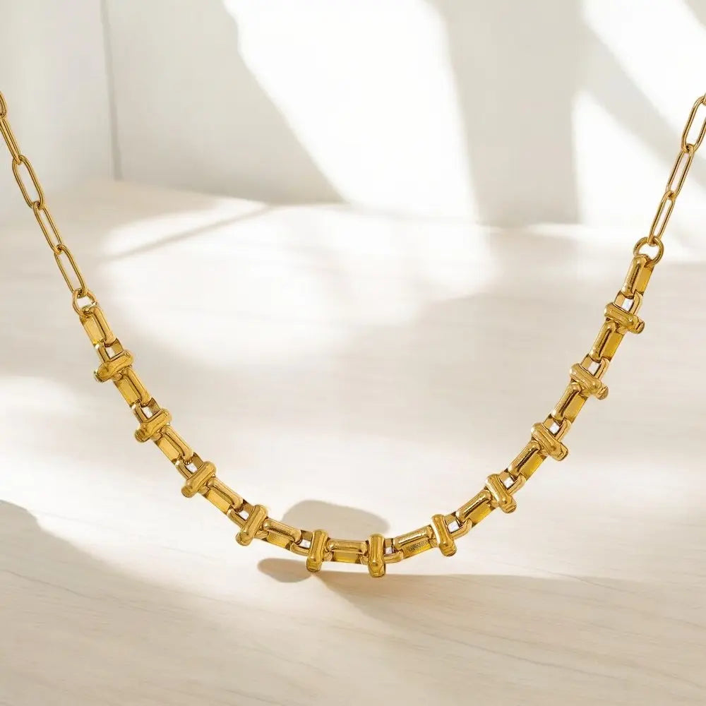 Gold necklace on a light background