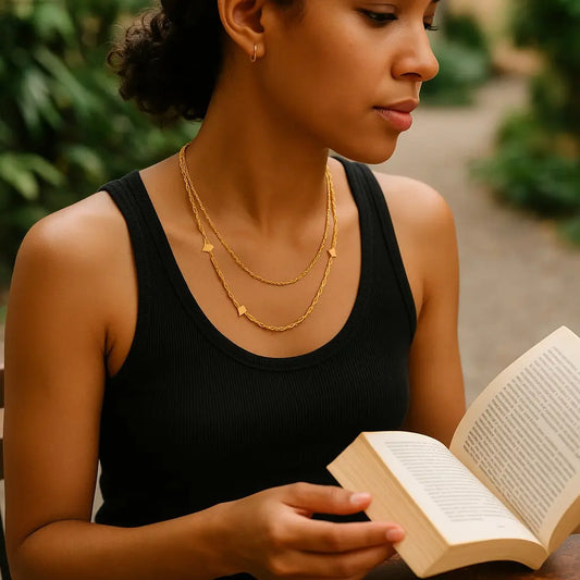 Woman reading a book outdoors with greenery in the background
