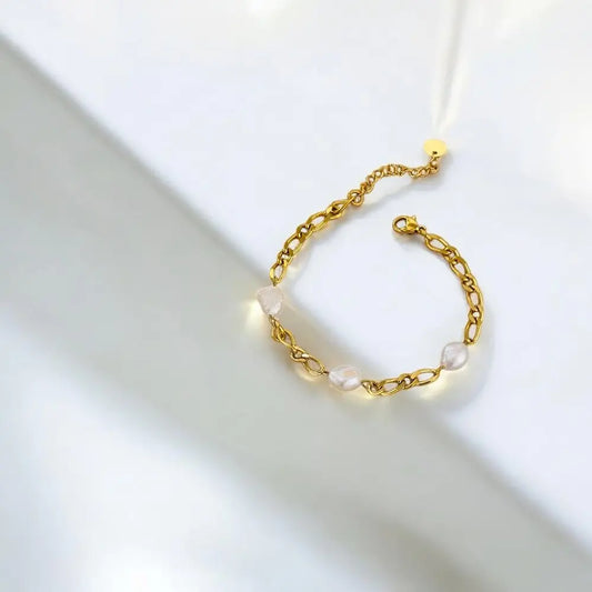 Gold bracelet with pearls on a light background