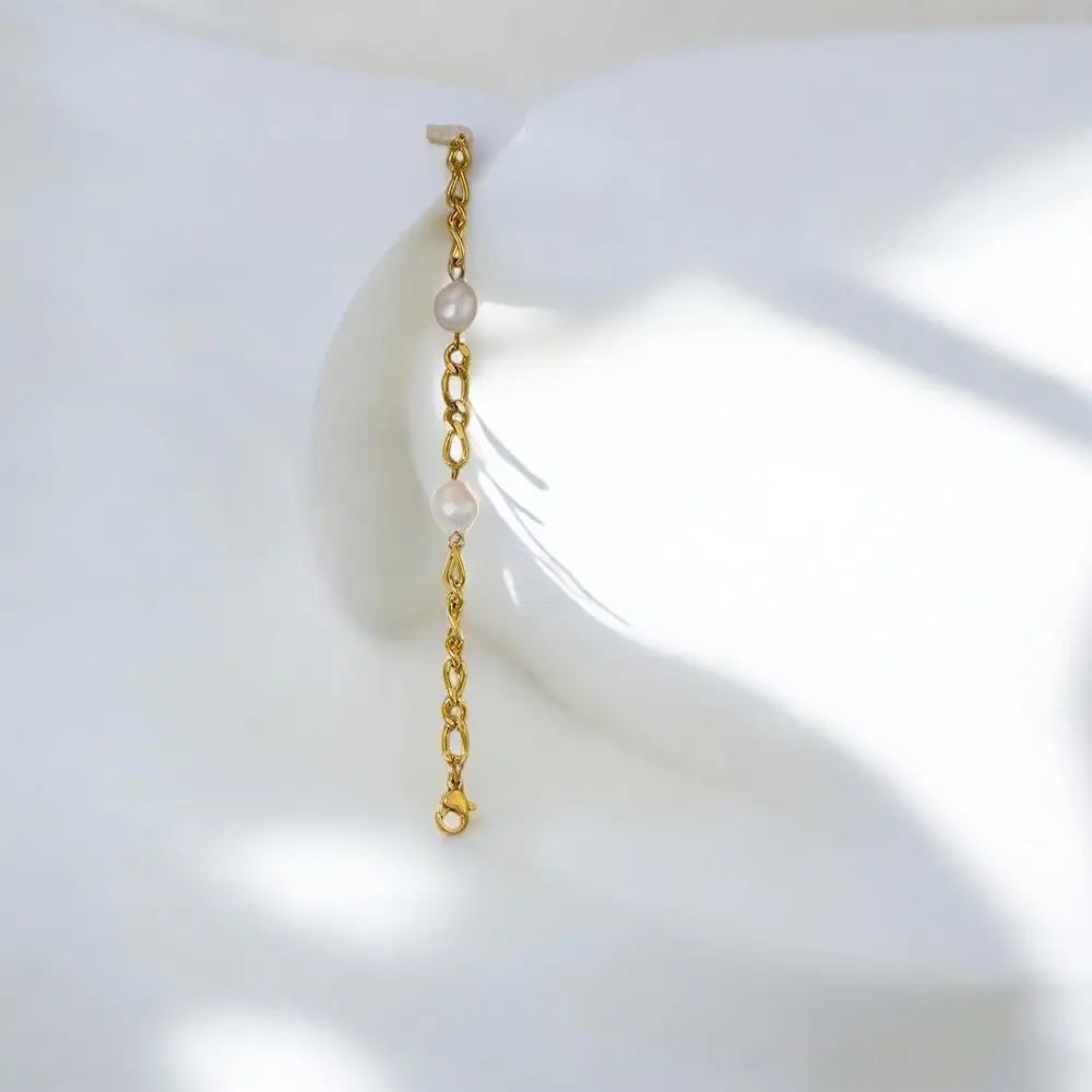 Gold chain earring with pearls on a white background